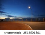 The street light illuminates the quiet seaside road at night.