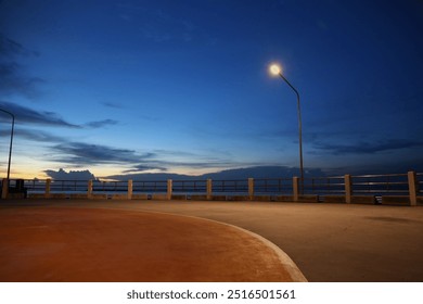 The street light illuminates the quiet seaside road at night. - Powered by Shutterstock