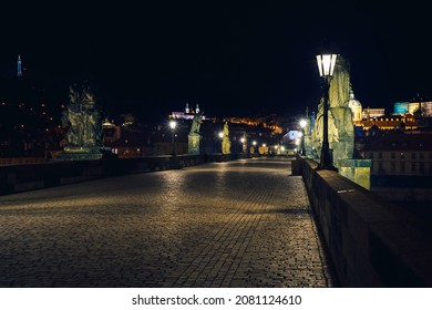 Street light lamp and paving sidewalk on the empty Charles Bridge on the Vltava River at night in the center of Prague