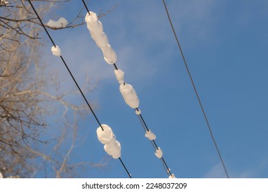 Street lighting electric wires under the snow.Highvoltage wires after a snowfall.
