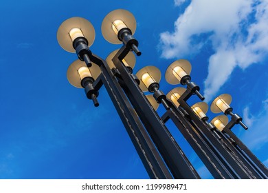Street lights against the blue sky with clouds. Bottom-up view.