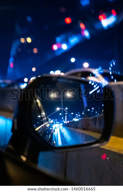 a\
street lights in the side view car mirror at night\
