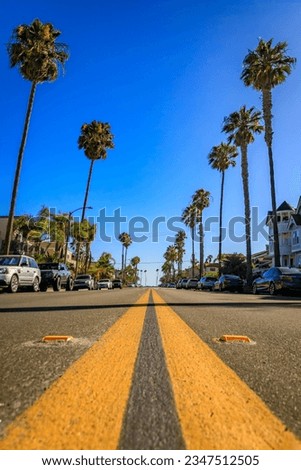 A street lined with palm trees, leading to the Pacific Ocean in Huntington Beach, Orange County, California famous for surfing