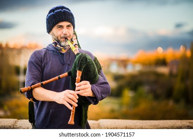 Street musician bagpiper playing traditional folk music in Spanish streets. Galician and Asturias culture historical music