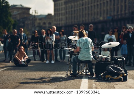 street musician drummer and crowd of people on blur background
