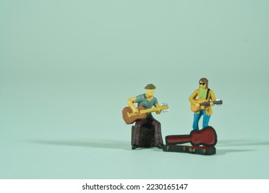 Street musician with guitar making music, miniature figures scene, light background - Shutterstock ID 2230165147