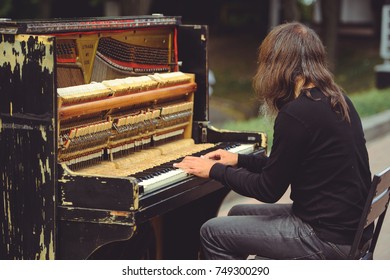 Street Musician Playing The Old Shabby Piano.