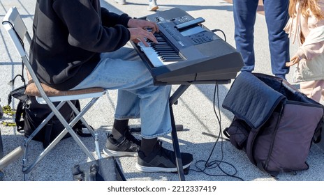 A Street Musician Plays The Synthesizer. A Little Girl Throws Money Into A Bag. Lifestyle