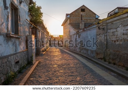 Street of the Old Town of Evpatoria at sunset. Narrow streets with stone pavements of the old resort town. Walking tour route