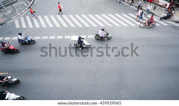 street on the\
top view with people are going acroos crosswalk sign on the road\
and car and motorcycle (Aerial\
photo)