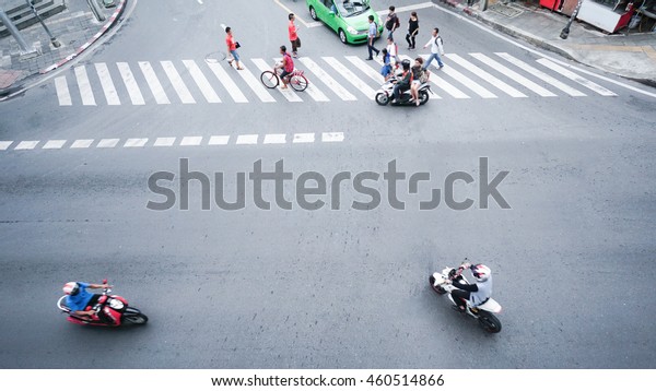 street on the\
top view with people are going acroos crosswalk sign on the road\
and car and motorcycle (Aerial\
photo)