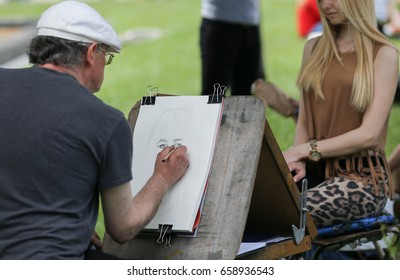 Street Painter (artist) Draws Portrait Of Girl  - Kiev, Ukraine - May 27, 2017