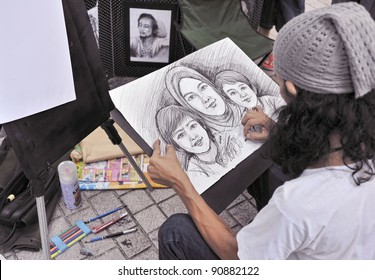 A Street Painter Sketching A Family Portrait