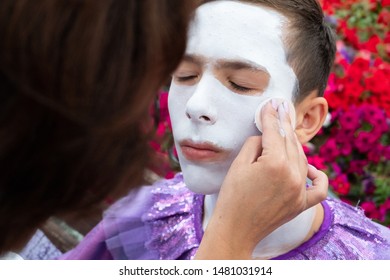 Street Performer Clown With A White Face. Makeup Artist Makes Up Boyfriend Teen.