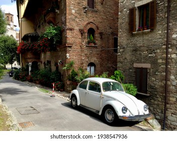 Street in Perugia, Umbria. Retro car, medieval building, geranium in pot, stone wall. Date of photo is 04.10.2015.