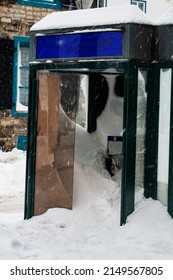 Street phone booth close-up completely covered with snow after strong storm in Quebec city