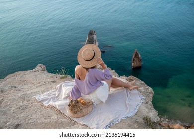 Street Photo Of A Beautiful Woman With Dark Hair In White Shorts And A Purple Sweater Having A Picnic On A Hill Overlooking The Sea