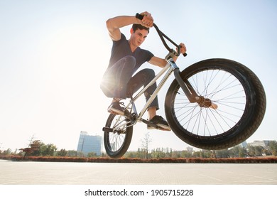 Street portrait of a bmx rider in a jump on the street in the background of the city landscape - Powered by Shutterstock