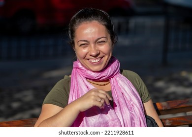 Street Portrait Of A Happy And Laughing Woman 35-40 Years Old With A Pink Scarf Around Her Neck On A Neutral City Background, Sunny Day, Summer Weather.