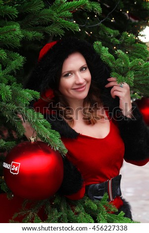 Street portrait of smiling beautiful young woman on the festive Christmas fair. Lady wearing classic stylish winter knitted clothes. Close up