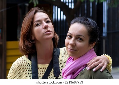 Street Portrait Of Two Women 35-40 Years Old Embracing Each Other. Concept: Female Friendship And Love, Two Female Friends In Life.