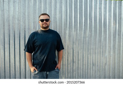 Street portrait of a young bearded man wearing grey blank t-shirt standing on the street. Mock-up for print. T-shirt template. - Powered by Shutterstock