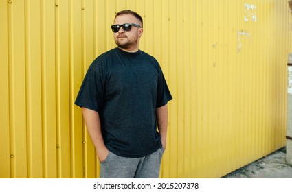 Street portrait of a young bearded man wearing grey blank t-shirt standing on the street. Mock-up for print. T-shirt template. - Powered by Shutterstock