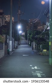 Street Road In The Night Illuminated By Lampposts In A Tokyo Residential Area.