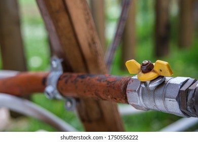 Street Rusty Water Pipe For Watering Flowers And Lawn. Yellow Tap For Opening And Closing The Water Supply For Irrigation.