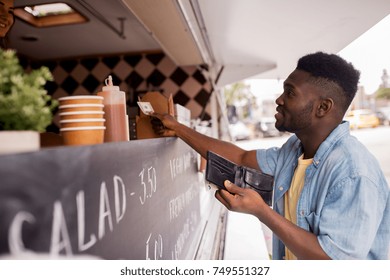 Street Sale, Payment And People Concept - Happy African American Young Man Buying Wok And Paying With Dollar Money At Food Truck