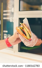 Street Sale And People Concept - Happy Seller Giving Burger To Customer At Food Truck