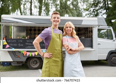 street sale and people concept - happy couple of young sellers at food truck - Powered by Shutterstock