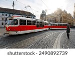 A street scene of a red streetcar moving along the tramway track, which curves before the landmark building of Municipal House by Republic Square (Náměstí Republiky) in Prague Old Town, Czech, Europe