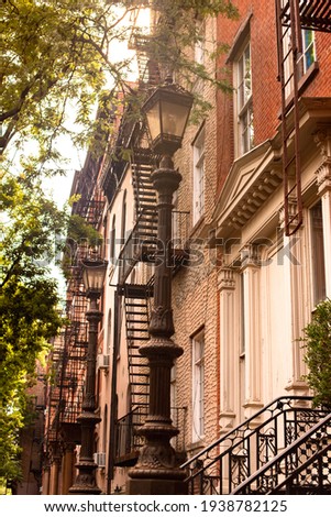 Street scene of residential neighborhood with a row of buildings seen from New York City Manhattan