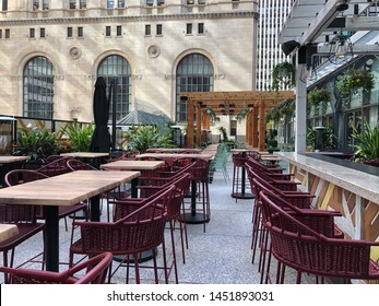 A Street Side Patio Of A Restaurant Bar Cafe, With Wooden Tables, Large Umbrellas, Outdoor Heaters, Waiting For Patrons On A Beautiful Sunny Summer Day In Downtown Toronto.