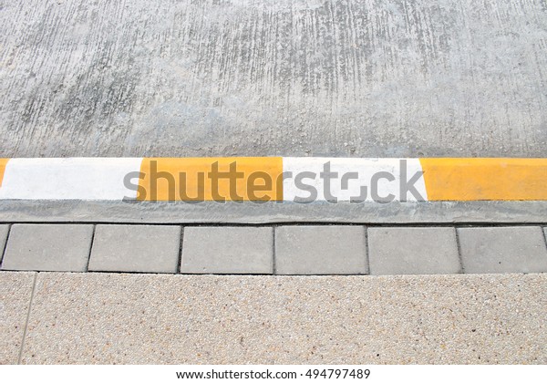 Street\
sidewalk with yellow lines to park\
temporarily.
