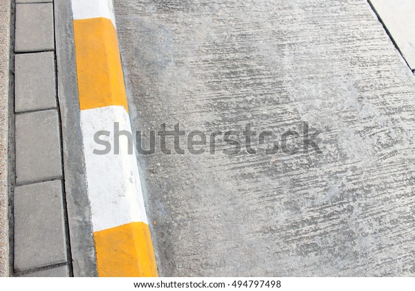 Street\
sidewalk with yellow lines to park\
temporarily.