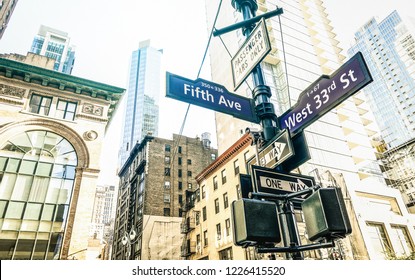 Street sign of Fifth Ave and West 33rd St in New York City - Urban concept and road direction in Manhattan downtown - American world famous capital destination on azure desaturated afternoon filter