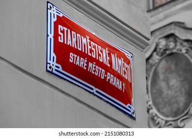 Street sign for Old Town Square in Prague. Sign in colour in black and white picture. Translation: Old Town Square, Old Town-Prague 1.