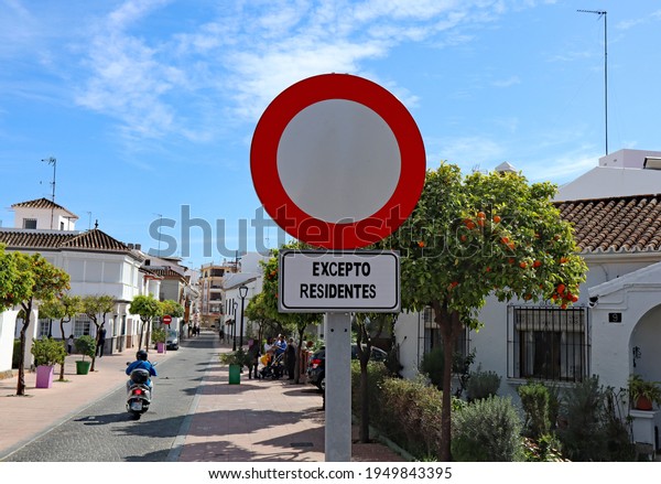 A street sign on a Spanish street advising that\
access to the street is for residents only. Excepto residentes\
translates to residents only