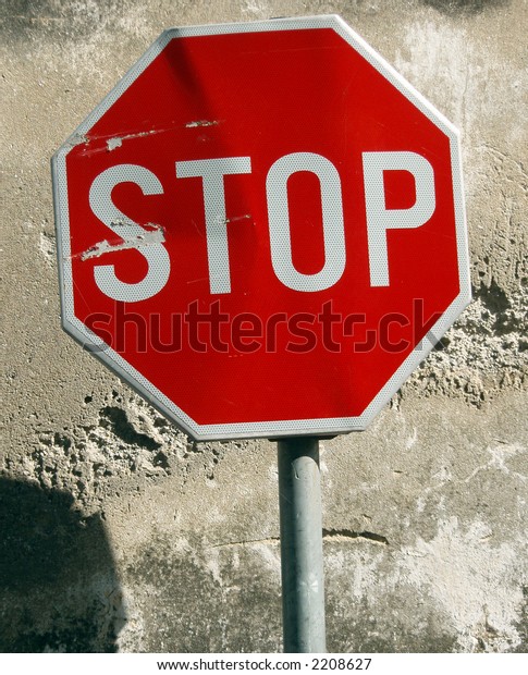 Street sign stop behind\
old wall surface