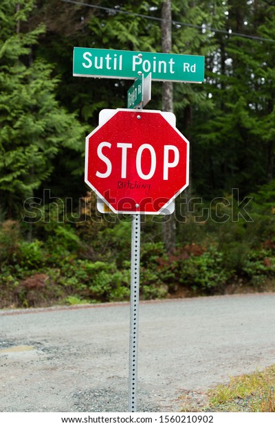 Street sign and stop sign with graffiti on\
Cortes Island, British\
Columbia