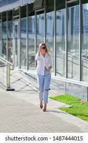 Street Style Fashion - Lady In White Shirt And Boyfriend Jeans Walking Along Business Centre