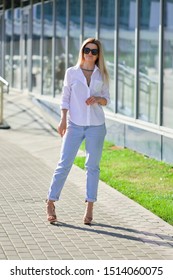 Street Style Fashion - Lady In White Shirt And Boyfriend Jeans Walking Along Business Centre