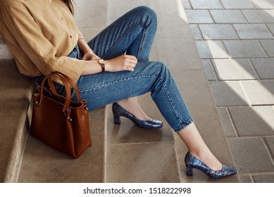 Street style, fashion trends concept: crop of fashionable woman`s outfit. Lady wearing casual clothes, python print, textured shoes with square toe, block heels. Copy, empty space for text
