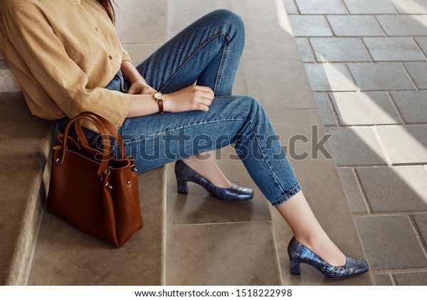 Street style, fashion trends concept: crop of\
fashionable woman`s outfit. Lady wearing casual clothes, python\
print, textured shoes with square toe, block heels. Copy, empty\
space for text