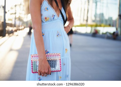 Street Style Image Of Fashionable Woman Wearing Appliqué Light Blue Summer Dress With Transparent Clutch Bag, Horizontal