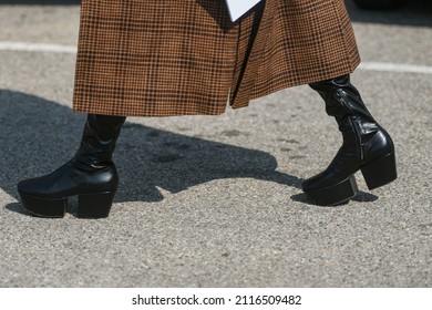 Street style outfit - woman wearing brown plaid coat and black leather platform boots - Shutterstock ID 2116509482