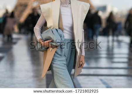 Street style outfit – Woman wearing an oversized vest and a pastel blue leather clutch bag – StreetStyleFW2020