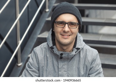 Street Style Portrait Of Handsome 30-35 Years Old Man Outdoors Sitting On The Stairs